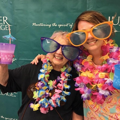 Anne Campbell (R) and coworker Finch VanDivier celebrate Juniper Anniversary Week with margaritas and a photo booth.